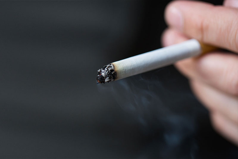 close up of a person smoking a cigarette