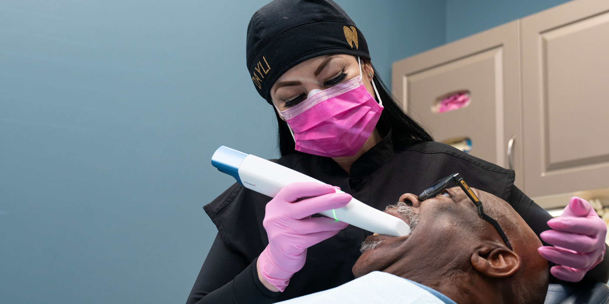 staff member examining patient for their dental treatment