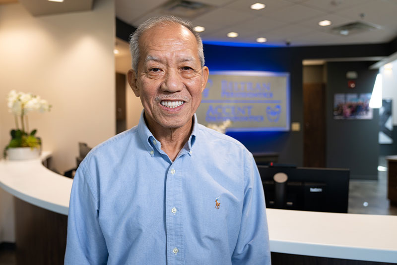 Headshot of Patient smiling brightly outside of the dental center