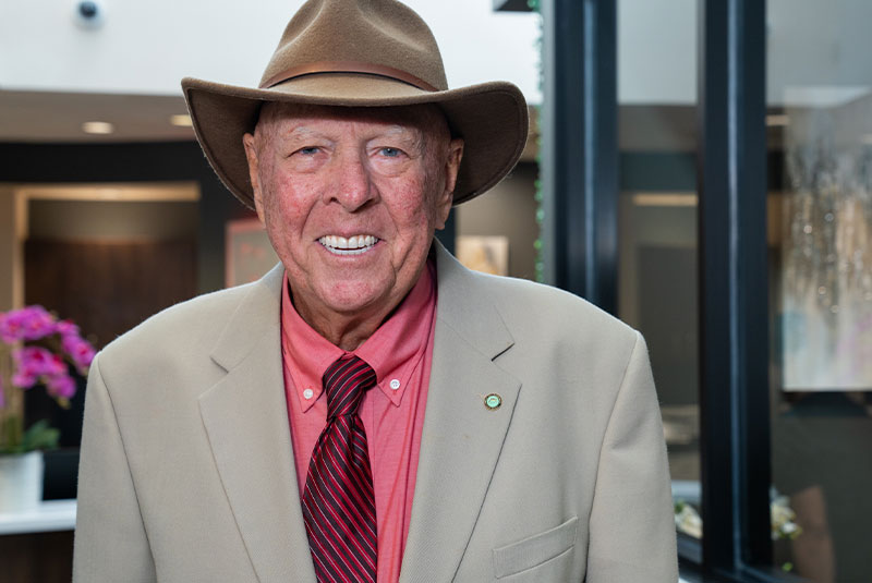 Headshot of Patient smiling brightly outside of the dental center