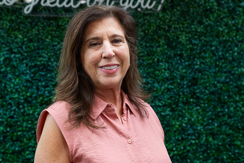 Headshot of Patient smiling brightly outside of the dental center