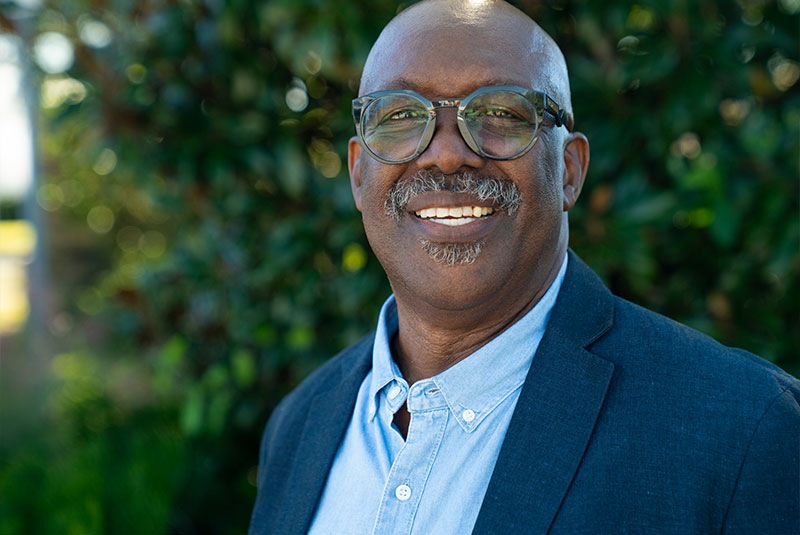 Headshot of Patient smiling brightly outside of the dental center